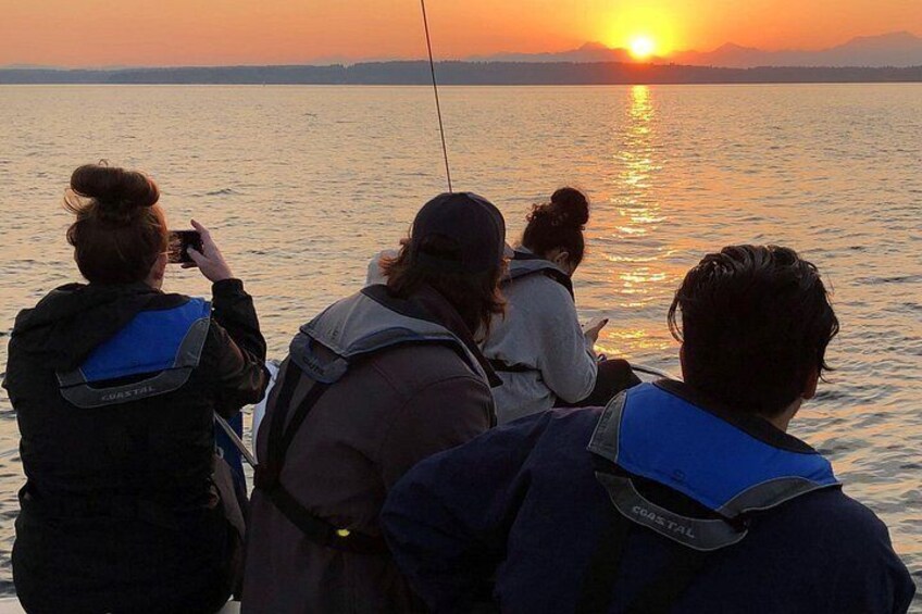 Een groep mensen op een boot tijdens de zonsondergang. 4
