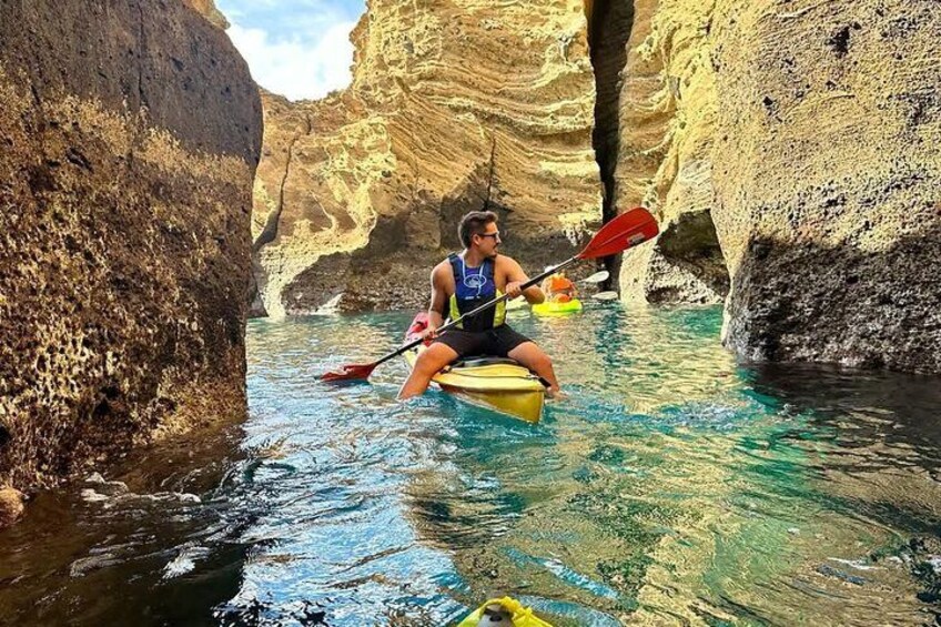 A person kayaking in a narrow canyon with clear water. 2