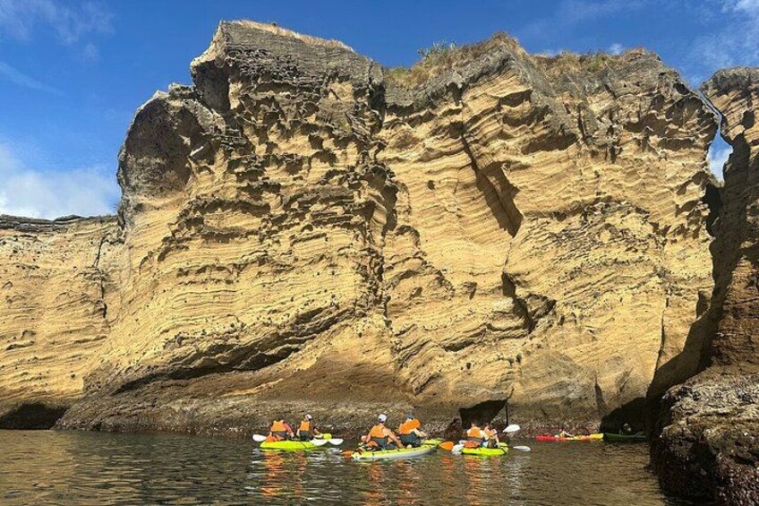 Kayakistas en un río tranquilo, con una gran formación rocosa al fondo. 2