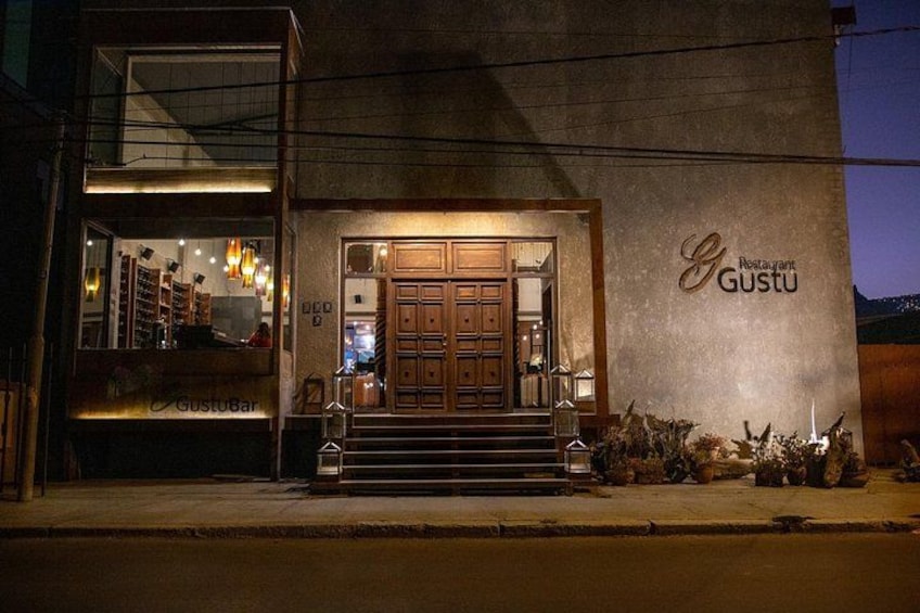 A restaurant named GustuBar with a wooden facade and a glass entrance. 5
