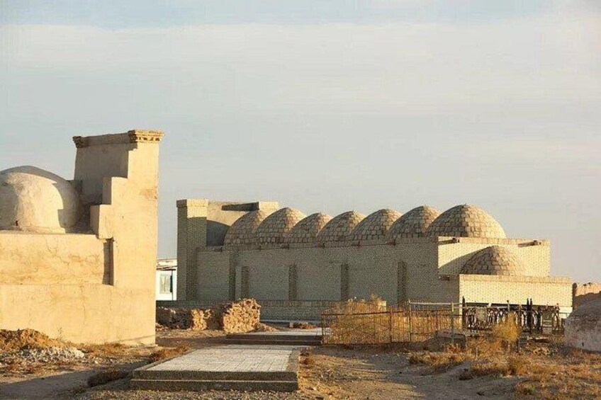 A historical building with multiple domed structures and a paved entrance. 1