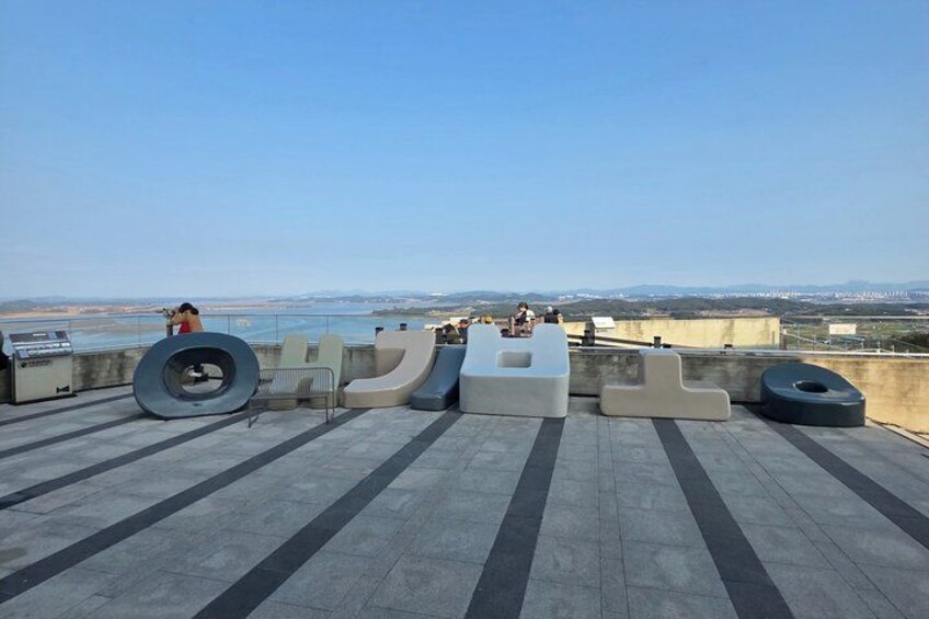 A rooftop with modern seating and a view of the coastline. 3