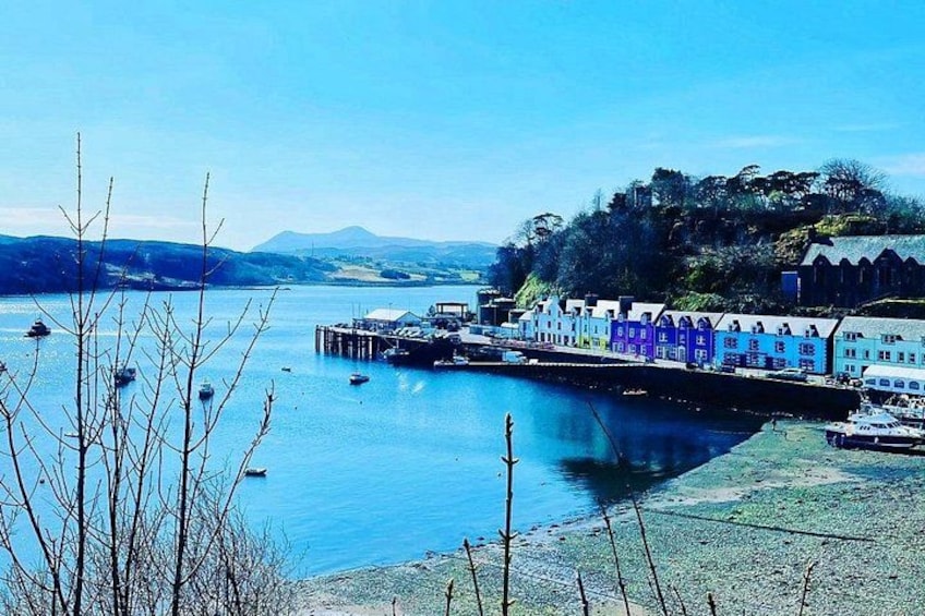A coastal town with colorful buildings, a pier, and boats on the water. 2