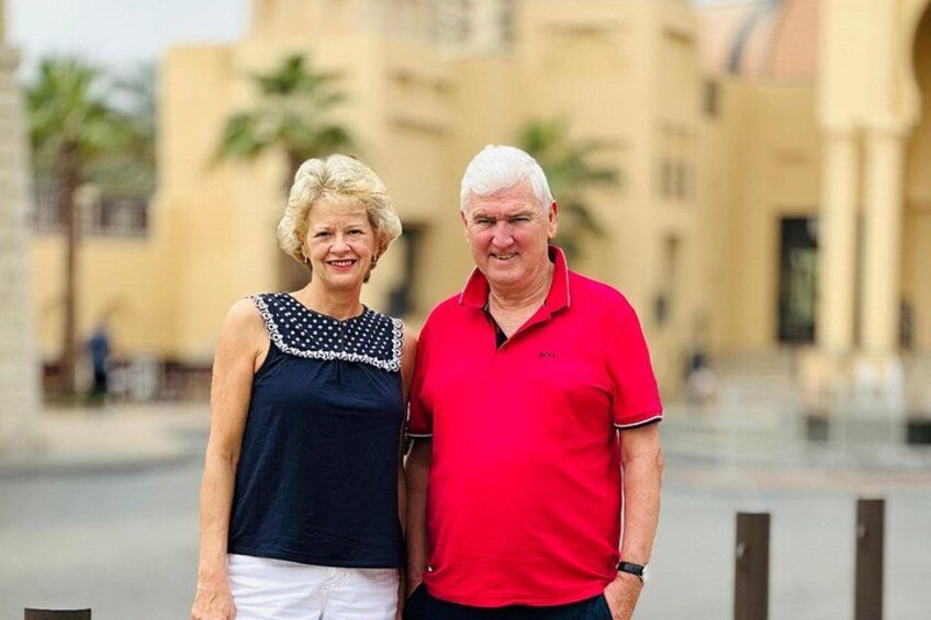 Two people standing in an outdoor area with a building in the background. 5