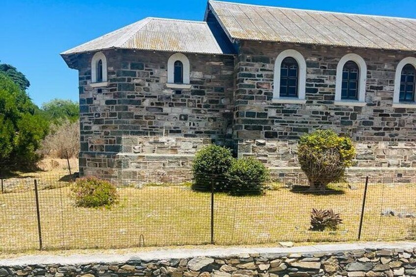 A stone building with arched windows and a sloped roof. 4