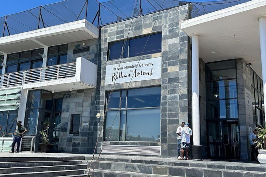 A modern building with a sign reading 'Nelson Mandela Gateway Rolleston Island.' 2