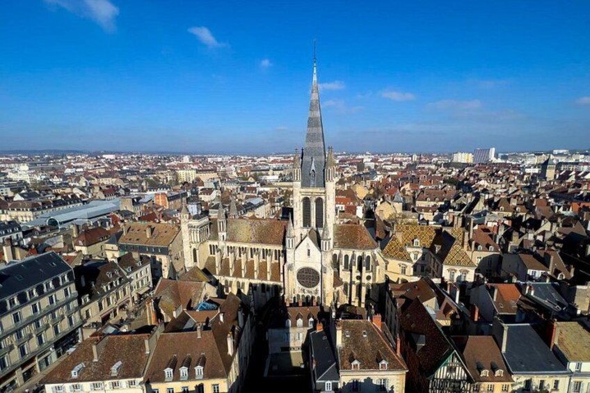 Une cathédrale dotée d’une haute flèche, entourée d’immeubles très rapprochés les uns des autres. 1