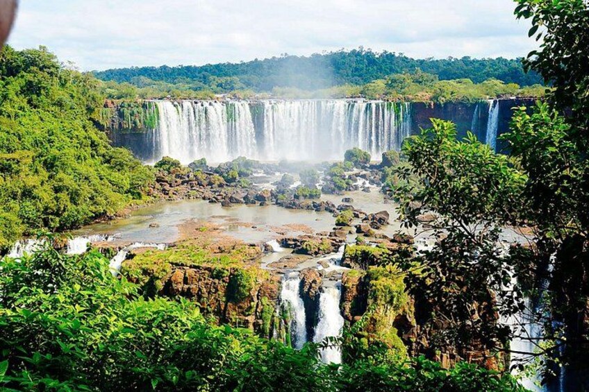 A waterfall cascading over rocks surrounded by lush greenery. 5