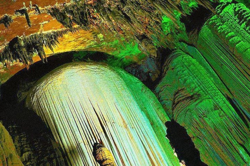 A cave with stalactites and stalagmites, illuminated by green lighting. 5