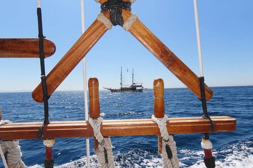 Una struttura in legno con corde, una nave sullo sfondo e l'oceano. 4