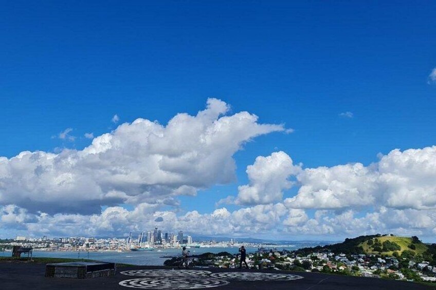 A city skyline, a large cloud formation, and a park with a circular design. 2