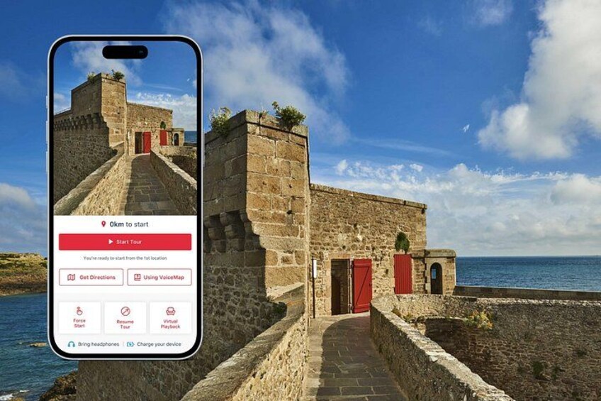 Un smartphone affichant l’interface d’une application de visites guidées, avec en arrière-plan un bâtiment historique en pierre et un ciel dégagé. 1