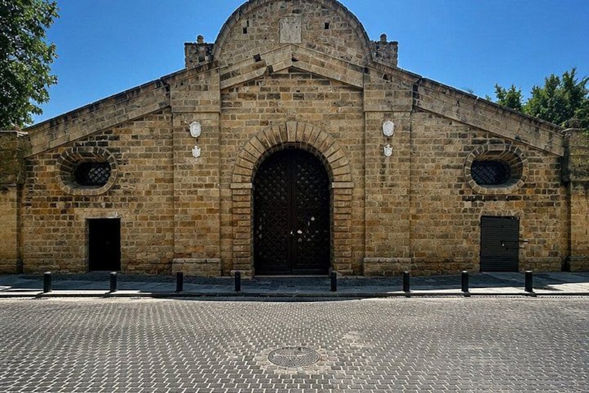 Un bâtiment historique en pierre, doté d’une grande entrée en arc de cercle, de deux petites fenêtres en arc de cercle et d’un dôme sur le toit. 2