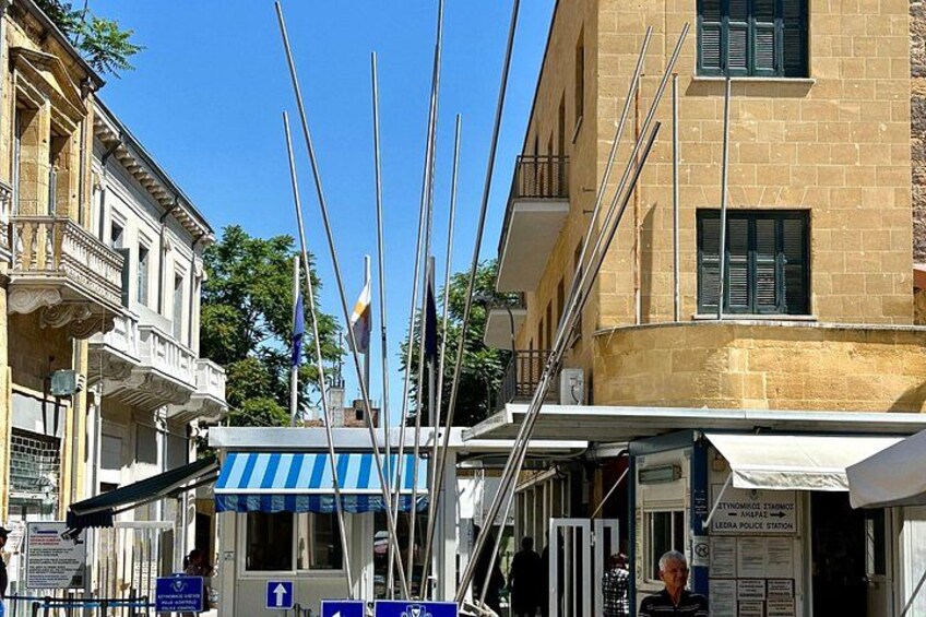 Eine Straße mit Gebäuden, einem blau-weiß gestreiften Markisen und Flaggen. 5