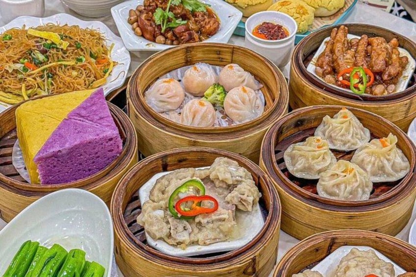 Ett urval av asiatiska rätter, inklusive dumplings och nudlar, serverade i ångkokare av bambu. 4