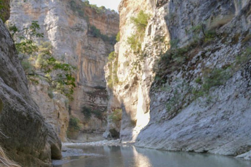 Un cañón con un río, riscos rocosos y vegetación escasa. 3