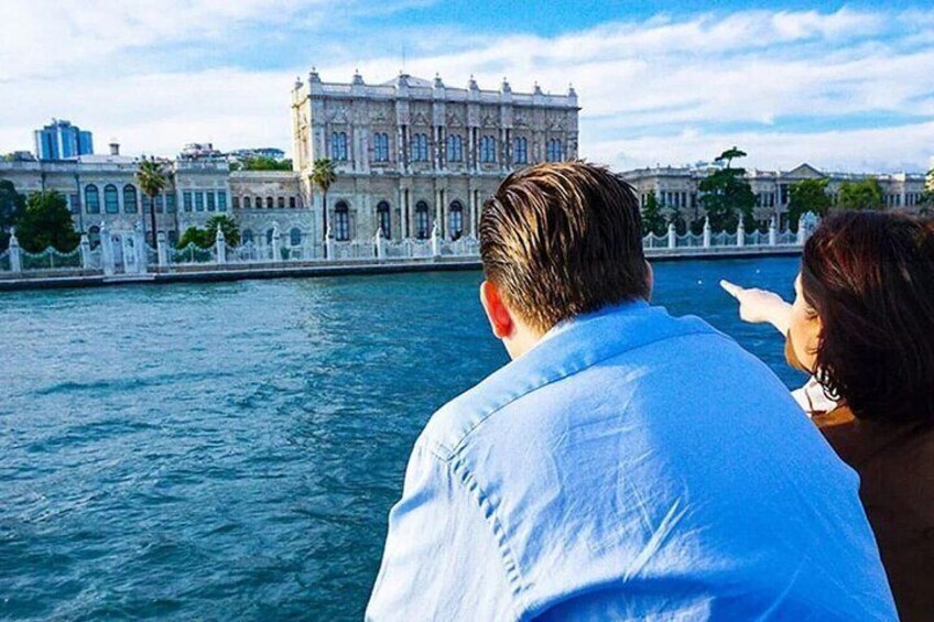 A man and woman looking at a historic building across a body of water. 1