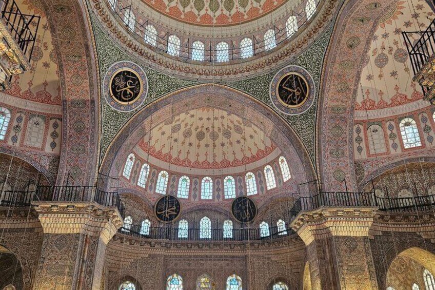 A grand interior with intricate tile work, domed ceilings, and arched windows. 4