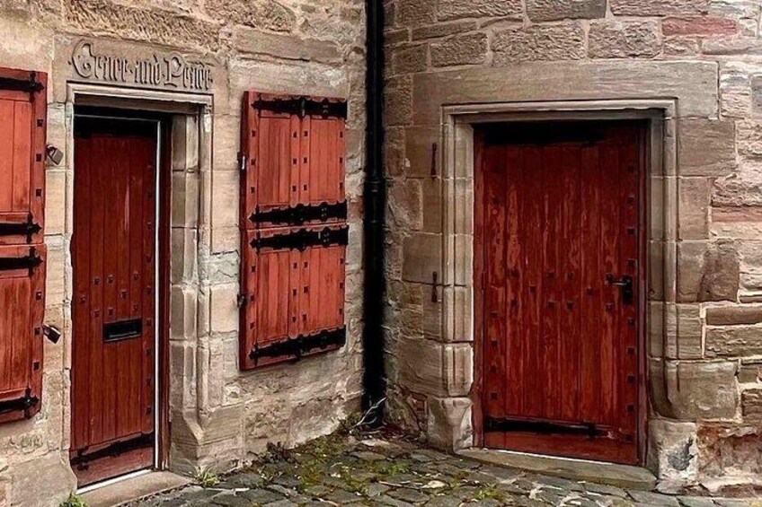 A stone building with wooden doors and shutters. 2