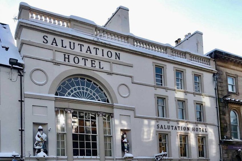 The exterior of the Salutation Hotel with a large arched window and a sign above the entrance. 5