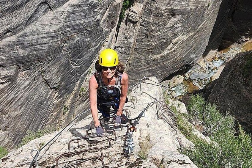 A person climbing a rocky terrain with a helmet and harness. 4