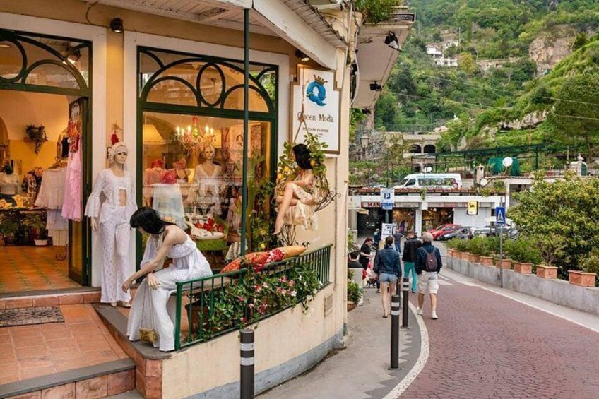 Une boutique avec des mannequins et, en arrière-plan, une colline offrant un paysage pittoresque. 4