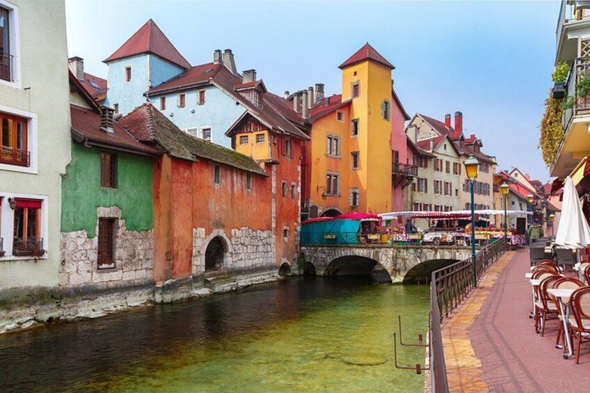 Un canal bordé d’immeubles aux couleurs vives, un pont et des terrasses aménagées le long du chemin. 2