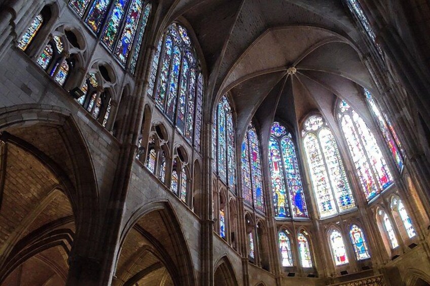 A cathedral interior with stained glass windows and Gothic arches. 3