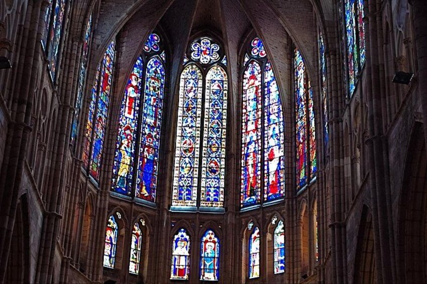 A cathedral interior with large stained glass windows and arched ceilings. 4