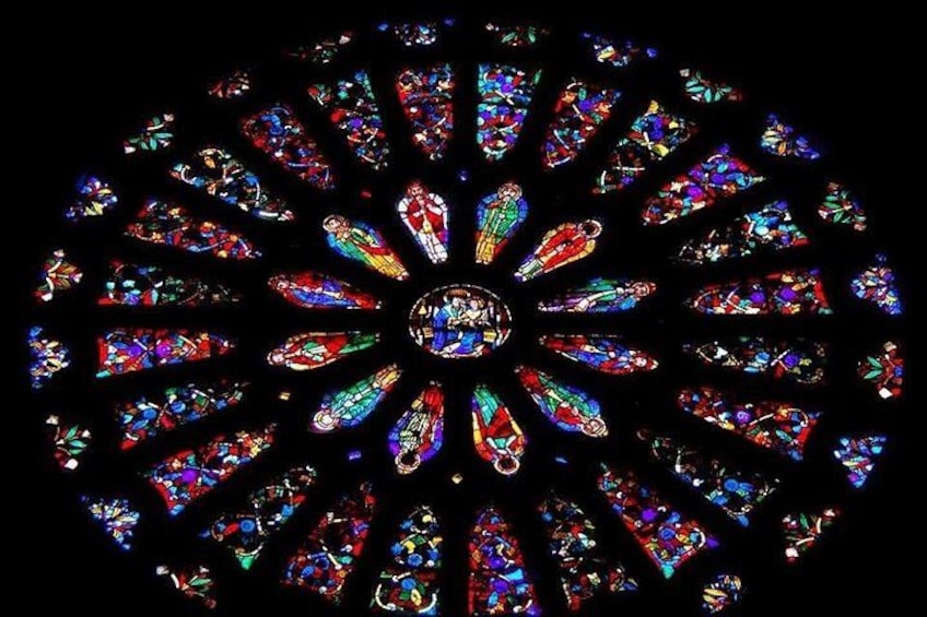 A circular stained glass window with intricate designs and vibrant colors. 5