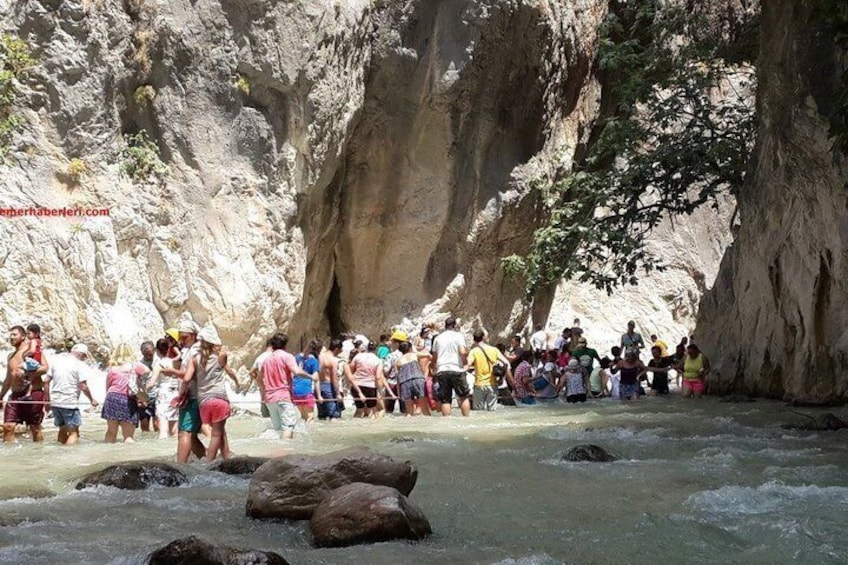 A group of people standing by a river in a rocky canyon. 4