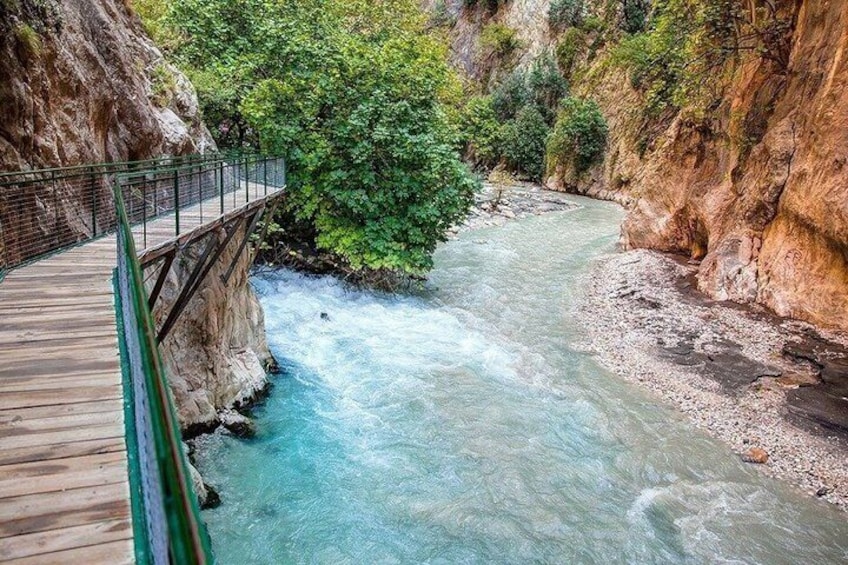 A river flowing through a canyon with a wooden bridge. 3