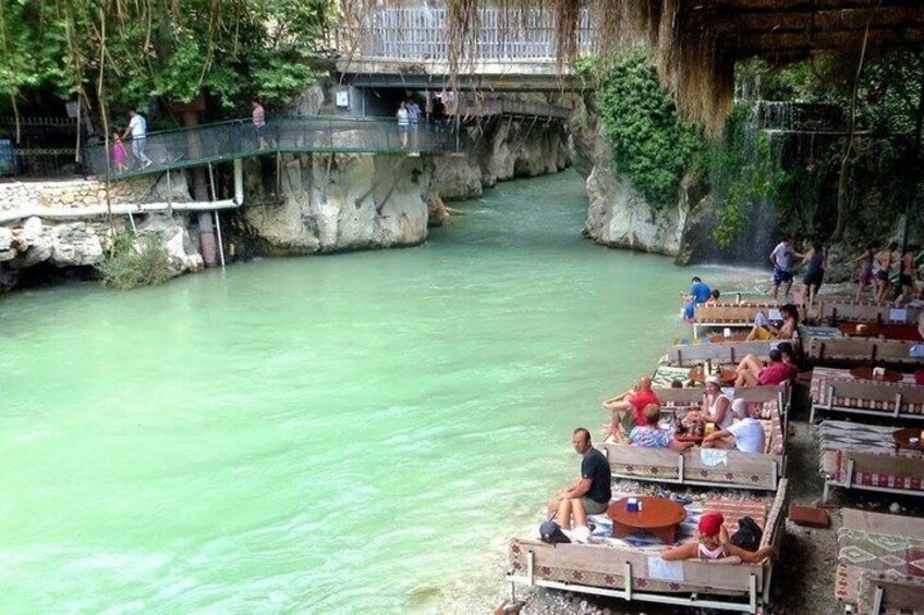 A river with people on boats and a bridge. 2