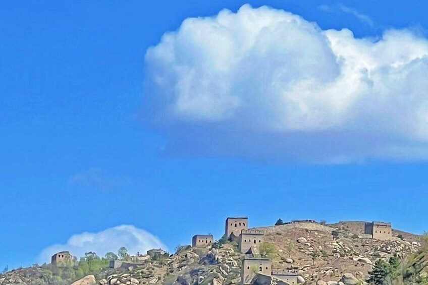 A historical fortress on a hill with clear blue sky and clouds. 2