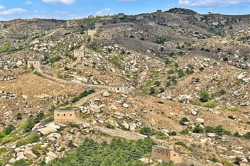 A rugged landscape with scattered ruins and rocky terrain. 1