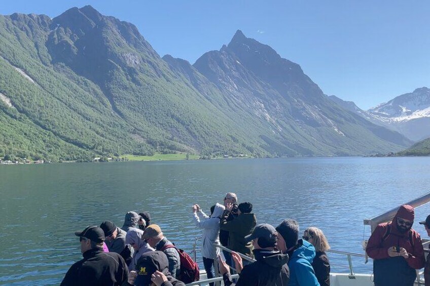 A group of people on a boat near a lake surrounded by mountains. 5