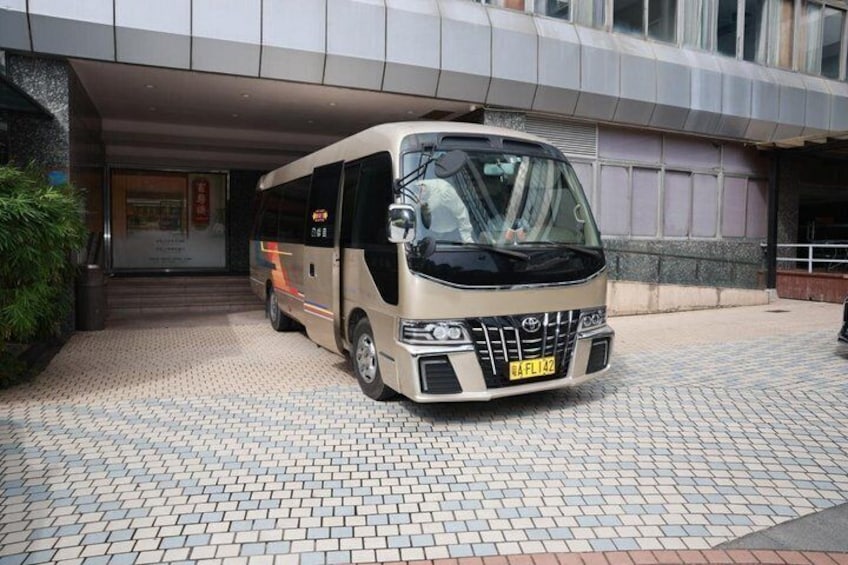 En buss står parkerad framför en byggnad med en entré som är klädd med kakel. 2