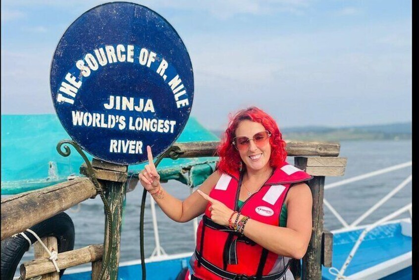 Una persona señala un cartel que dice 'The Source of R. Nile Jinja Mundo’s Longest River'. 1