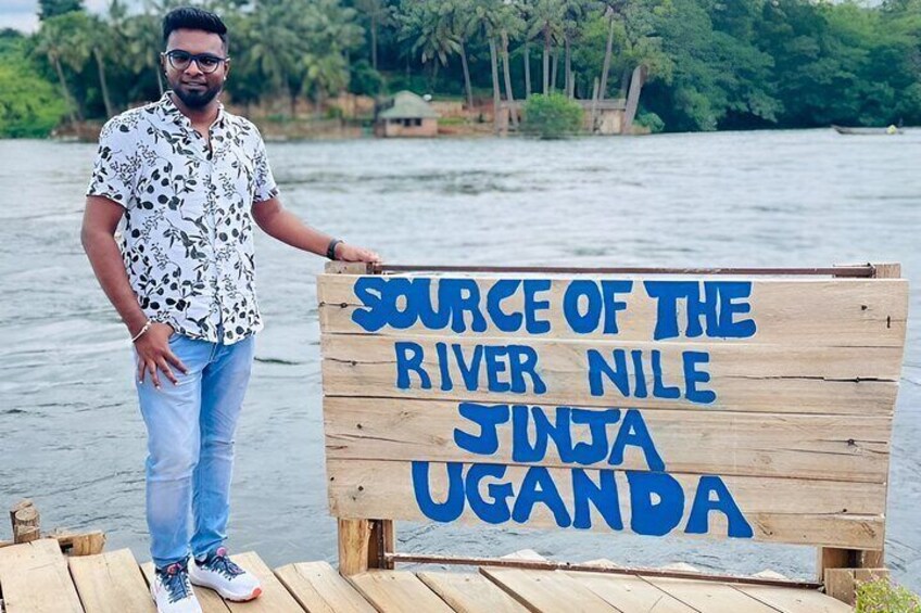 Un letrero de madera con la inscripción 'SOURCE OF THE RIVER NILE JINJA UGANDA'. 2