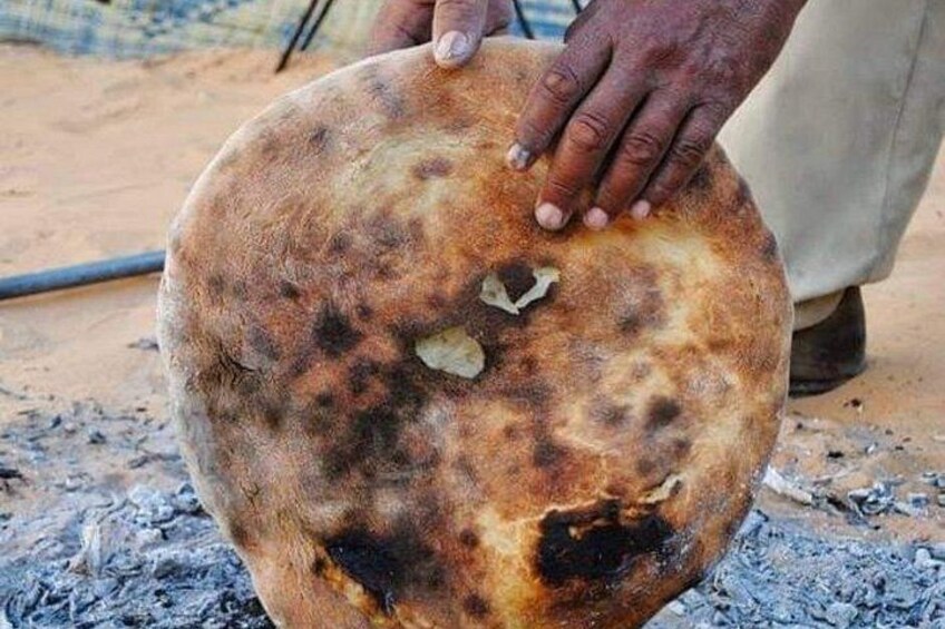 A round flatbread with charred spots, held by a person. 5