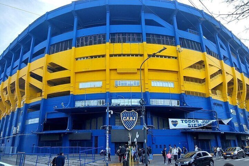 A large, multi-tiered stadium with blue and yellow colors. 1