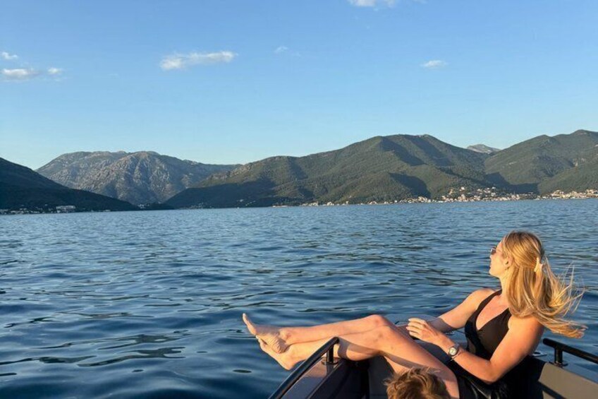 Eine Person auf einem Boot vor einer gebirgigen Landschaft. 4