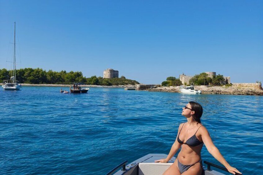 Eine Frau in einem Bikini auf einem Boot, Wasser, Segelboote und historische Gebäude. 3