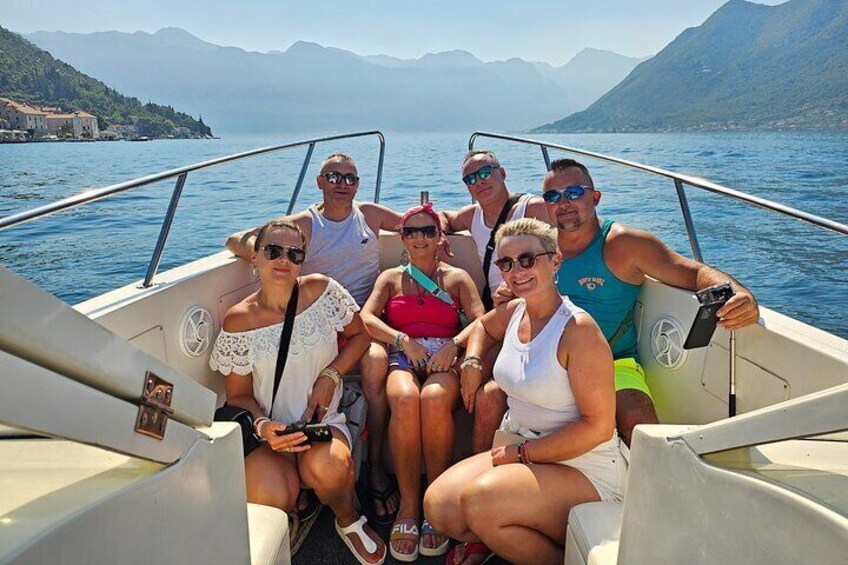 A group of people on a boat with a mountainous landscape in the background. 3