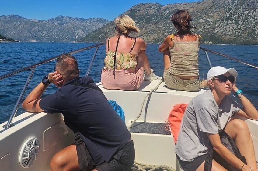A group of people on a boat with a mountainous landscape in the background. 2