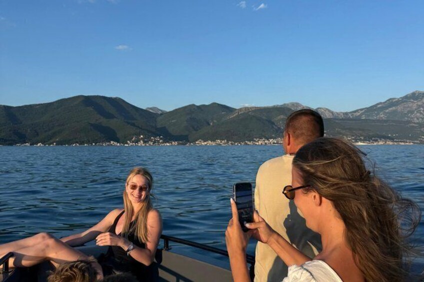 Ein Boot mit Personen auf dem Wasser, mit Bergen im Hintergrund. 5