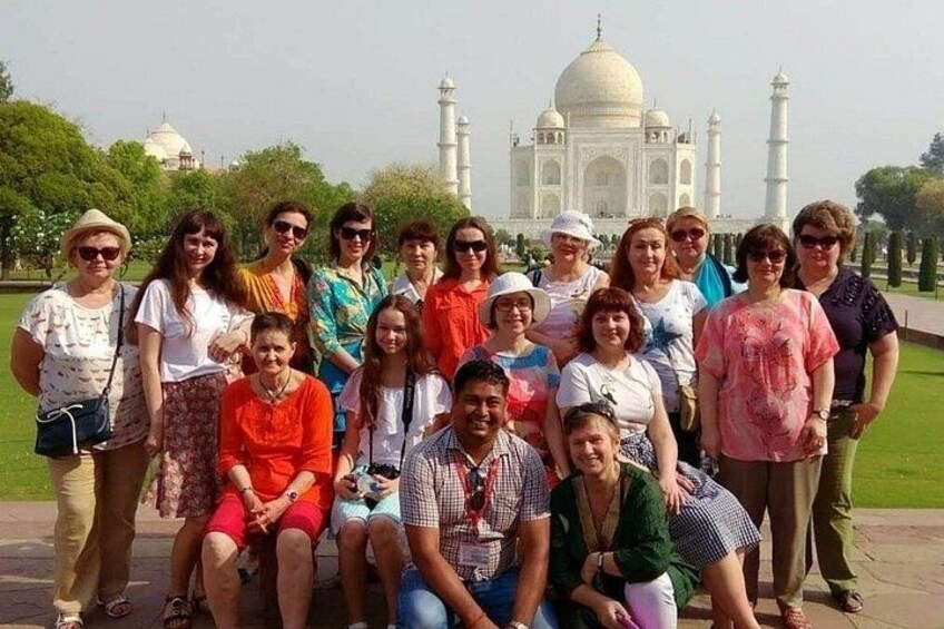 Eine Gruppe von Personen posiert vor dem Taj Mahal. 4