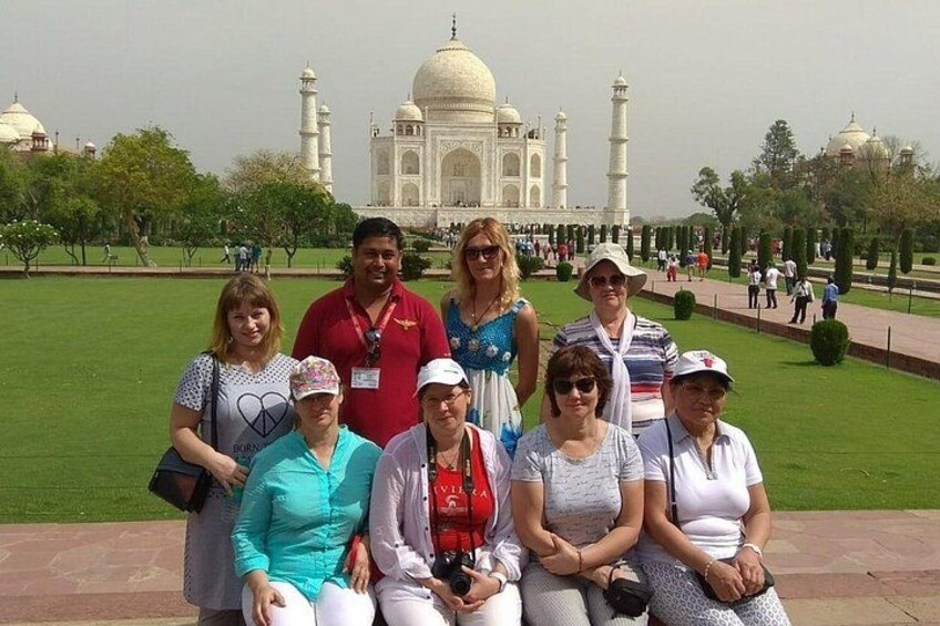 Eine Gruppe von Personen posiert vor dem Taj Mahal. 1