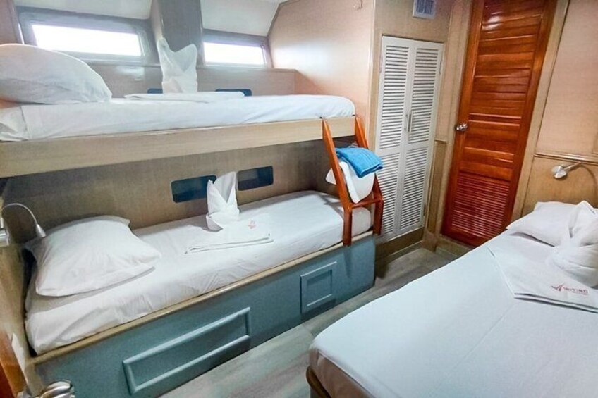 A bunk bed with a blue drawer, a wooden chair, and a wooden door. 4