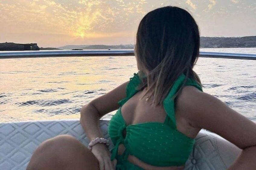 Eine Person sitzt in einem Boot, im Hintergrund ein Sonnenuntergang. 2